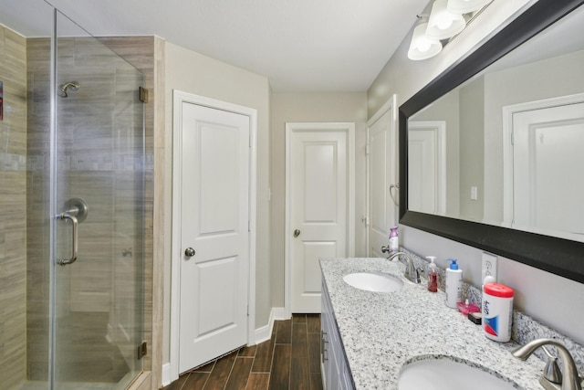 1006 Glacier Hill Dr, Houston, TX 77077 - bathroom with double vanity, a shower stall, wood finished floors, and baseboards