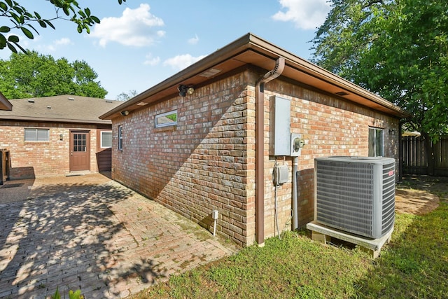 1006 Glacier Hill Dr, Houston, TX 77077 - view of side of home featuring central AC unit, brick siding, and a patio