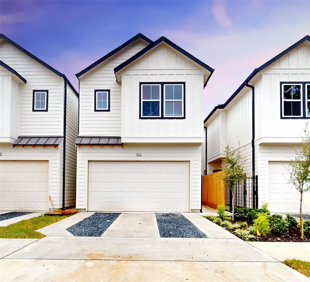 view of front facade featuring a standing seam roof, metal roof, a garage, board and batten siding, and driveway