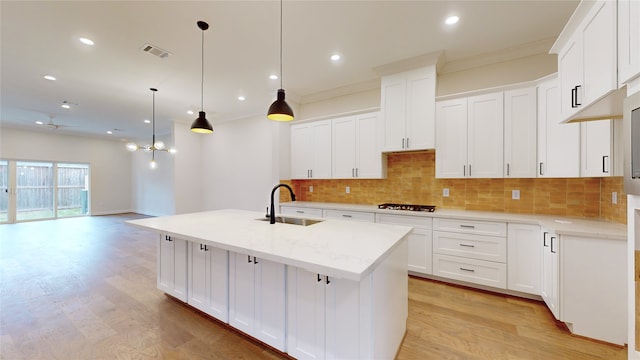 kitchen with a sink, visible vents, light wood-type flooring, and gas stovetop