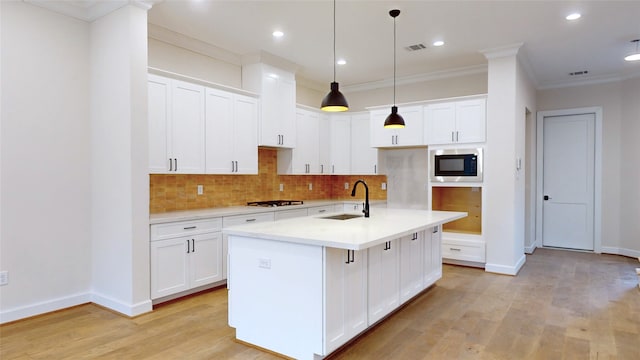 kitchen with a sink, light wood-style floors, gas stovetop, and built in microwave