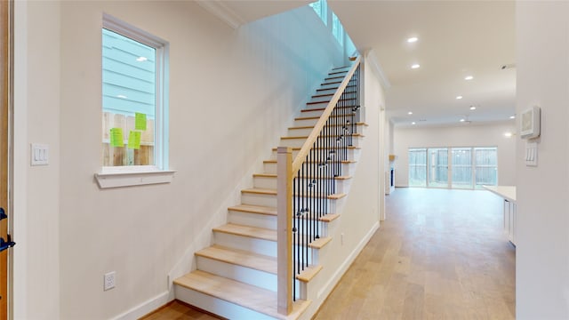 staircase featuring recessed lighting, baseboards, and wood finished floors