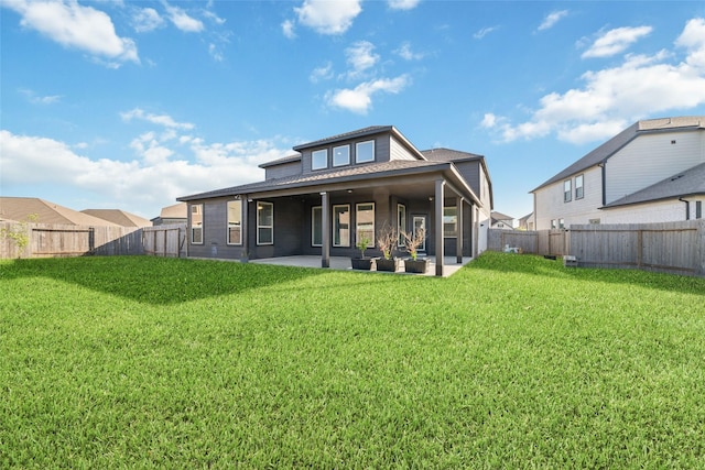 rear view of property featuring a yard, a fenced backyard, and a patio