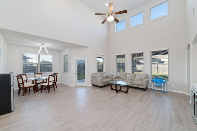 living area with plenty of natural light, light wood-type flooring, and ceiling fan