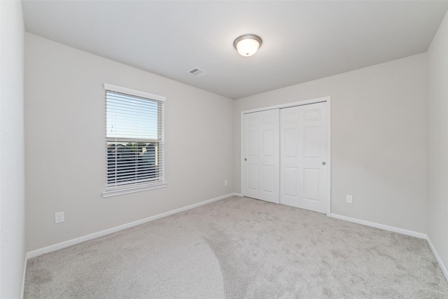 unfurnished bedroom with carpet flooring, baseboards, and visible vents