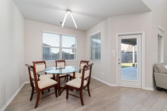 dining space with light wood-type flooring and baseboards