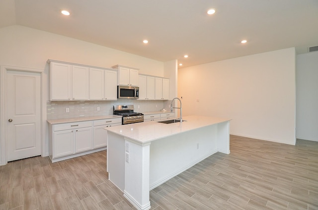 14211 Walworth Creek Ct, Rosharon, TX 77583 - kitchen featuring a sink, stainless steel appliances, backsplash, light countertops, and light wood-style floors