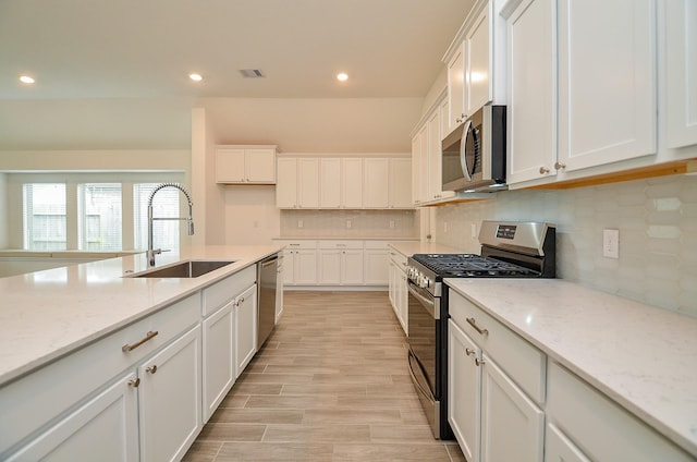 14211 Walworth Creek Ct, Rosharon, TX 77583 - kitchen with white cabinetry, stainless steel appliances, recessed lighting, and a sink