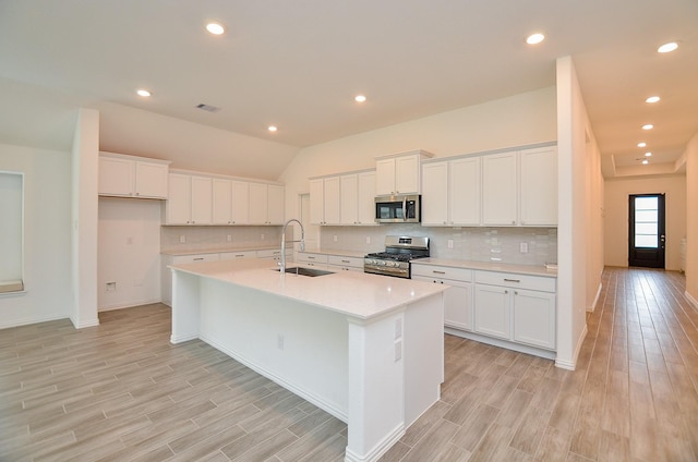 14211 Walworth Creek Ct, Rosharon, TX 77583 - kitchen with white cabinetry, stainless steel appliances, light wood-style flooring, and a sink