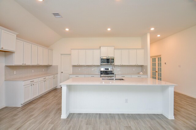 14211 Walworth Creek Ct, Rosharon, TX 77583 - kitchen featuring light countertops, tasteful backsplash, appliances with stainless steel finishes, and a kitchen island with sink