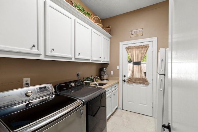 laundry area featuring a sink, cabinet space, and washer and clothes dryer
