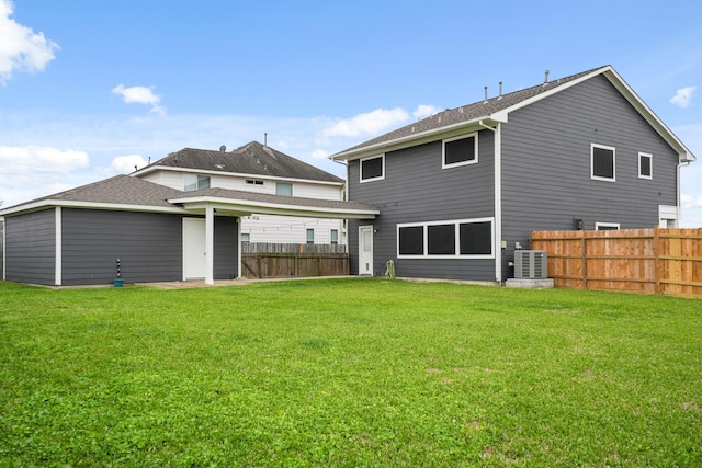 back of house with fence, central AC, and a yard