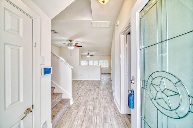 entrance foyer with light wood-style floors, a ceiling fan, visible vents, and baseboards