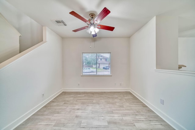 spare room featuring visible vents, ceiling fan, light wood-style floors, and baseboards