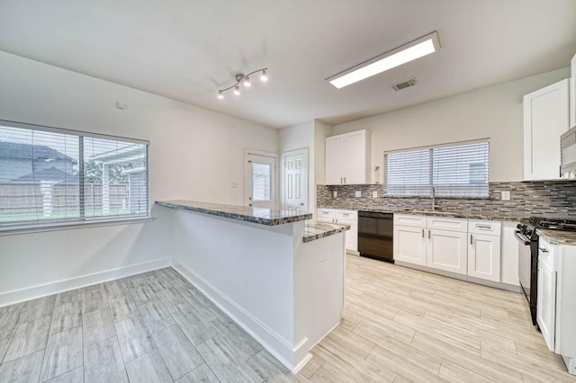 kitchen featuring visible vents, black appliances, stone counters, and backsplash