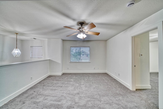 empty room with ceiling fan, carpet floors, and a textured ceiling