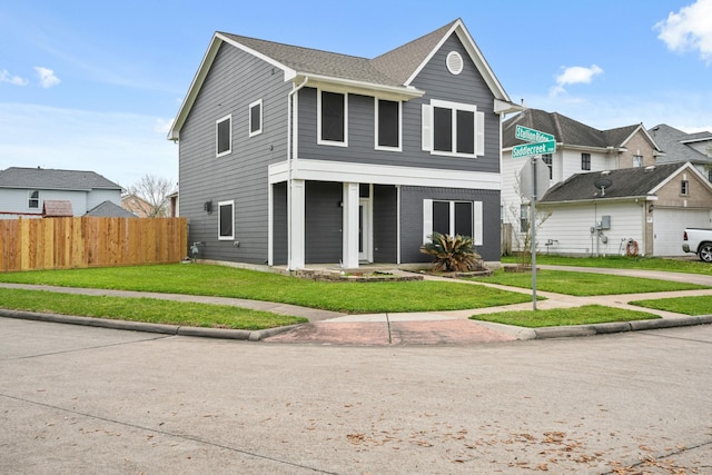 view of front of house with fence and a front lawn