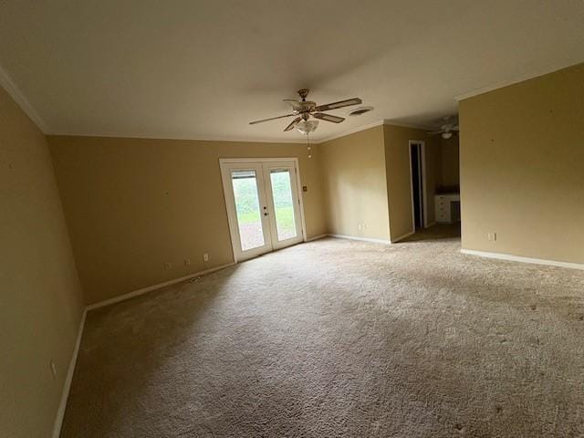 spare room featuring crown molding, ceiling fan, baseboards, and carpet