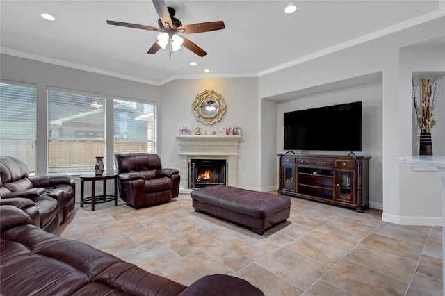 living room with crown molding, baseboards, a lit fireplace, recessed lighting, and a ceiling fan