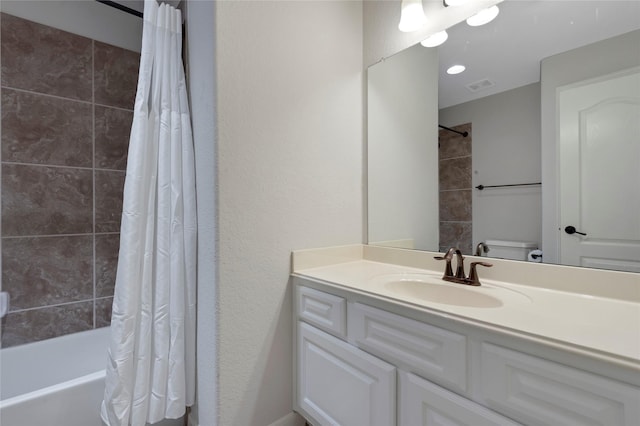 bathroom featuring toilet, visible vents, shower / bath combination with curtain, and vanity