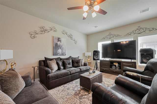 living area with visible vents, a ceiling fan, light wood-style floors, and a healthy amount of sunlight