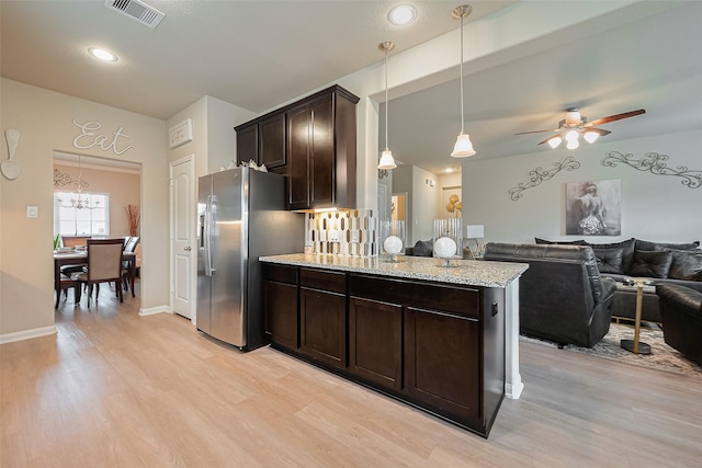 kitchen with open floor plan, dark brown cabinets, stainless steel refrigerator with ice dispenser, visible vents, and light wood finished floors