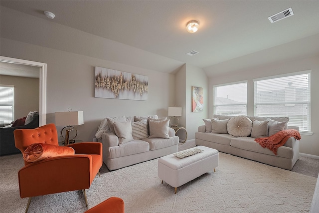 living room featuring a wealth of natural light, carpet flooring, visible vents, and lofted ceiling