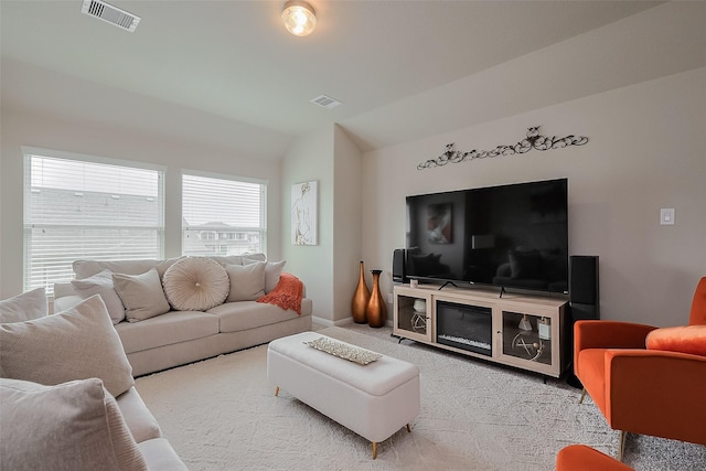 living room featuring carpet, baseboards, lofted ceiling, and visible vents