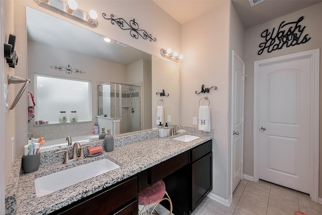 full bath with a sink, a shower stall, tile patterned flooring, and double vanity