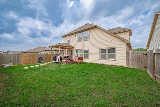 back of house with a yard and a fenced backyard