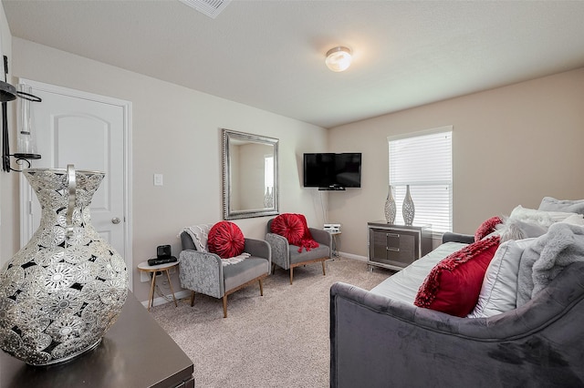 living area featuring visible vents, baseboards, and light colored carpet