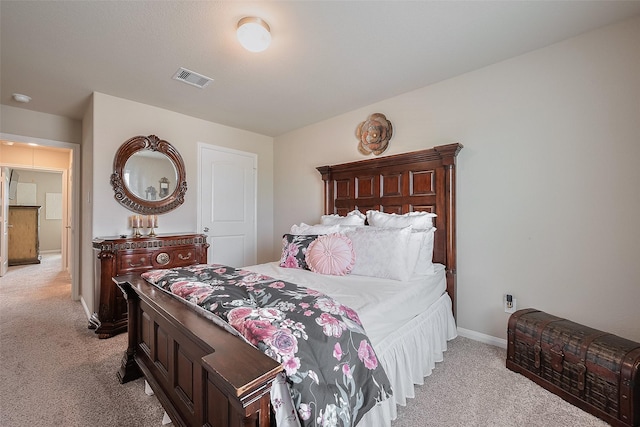 bedroom with visible vents, baseboards, and light carpet