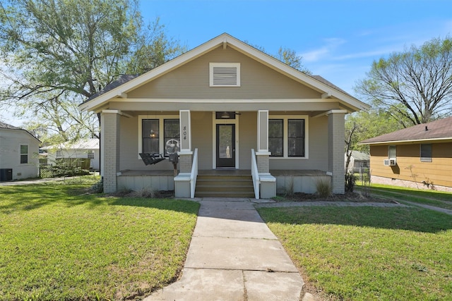 bungalow-style house with a porch, central AC, a front yard, and brick siding