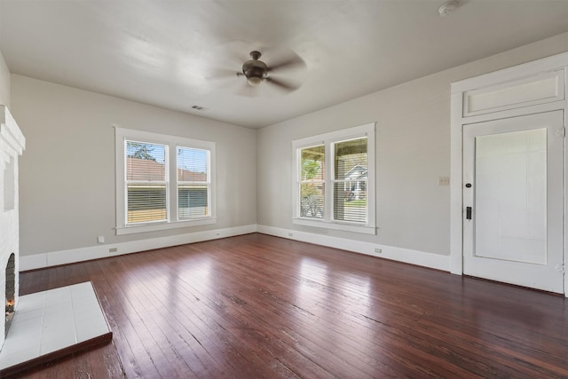 unfurnished living room with a wealth of natural light, ceiling fan, hardwood / wood-style flooring, and baseboards