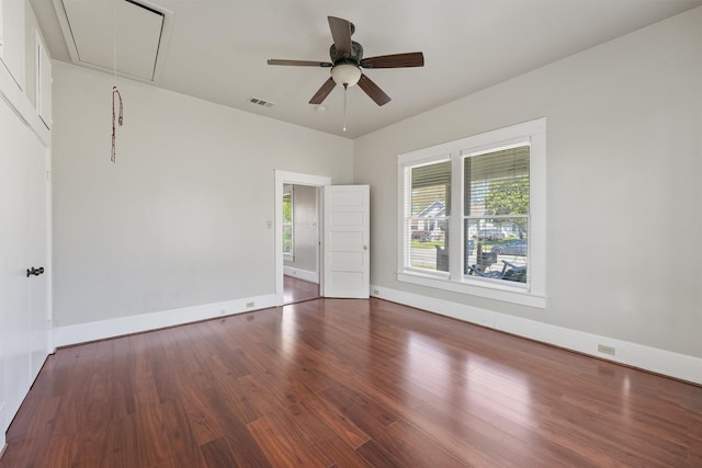 unfurnished room with attic access, visible vents, wood finished floors, and plenty of natural light