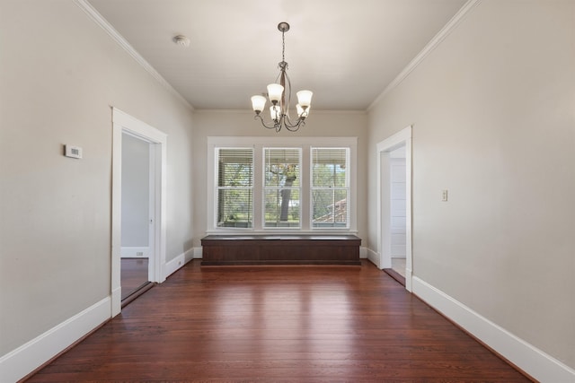 unfurnished dining area featuring baseboards, a notable chandelier, crown molding, and dark wood-type flooring