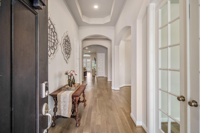 6919 Red Oak Dr, Katy, TX 77493 - foyer featuring arched walkways, wood finished floors, baseboards, and a tray ceiling