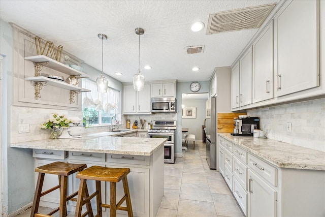 21263 Park Bluff Dr, Katy, TX 77450 - kitchen with decorative backsplash, stainless steel appliances, a peninsula, and visible vents