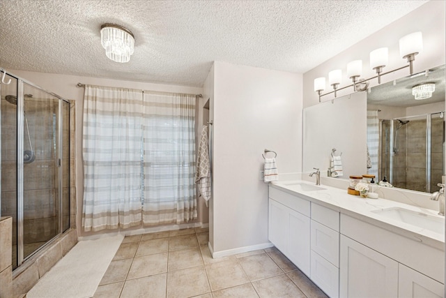 21263 Park Bluff Dr, Katy, TX 77450 - bathroom featuring a sink, tile patterned floors, a shower stall, and a textured ceiling