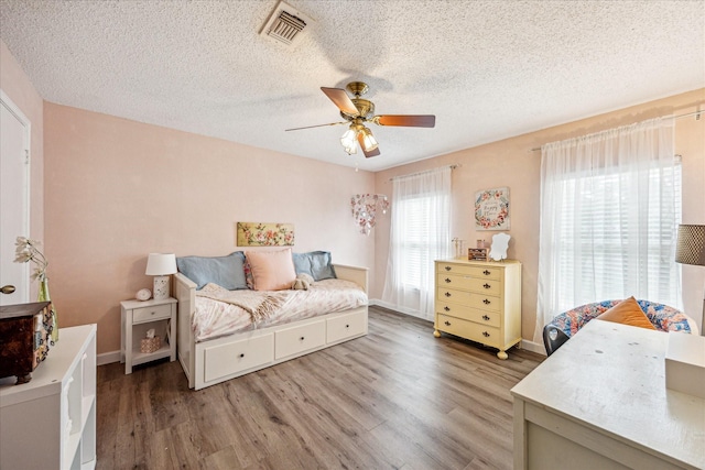 21263 Park Bluff Dr, Katy, TX 77450 - bedroom with visible vents, baseboards, ceiling fan, a textured ceiling, and light wood finished floors