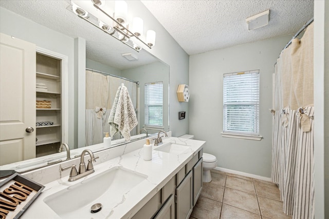 21263 Park Bluff Dr, Katy, TX 77450 - full bathroom with tile patterned flooring, a sink, a textured ceiling, and toilet