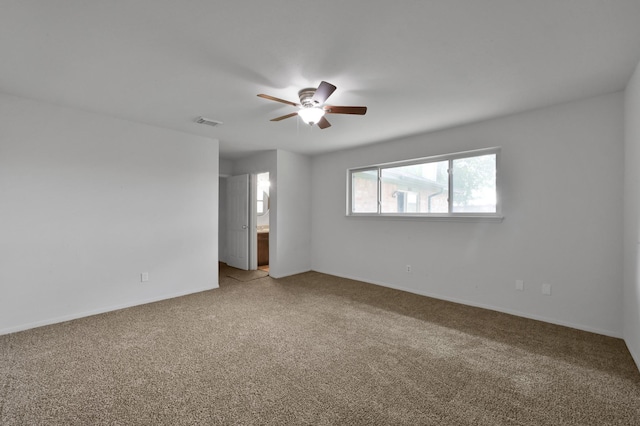 unfurnished room with light carpet, a ceiling fan, visible vents, and baseboards