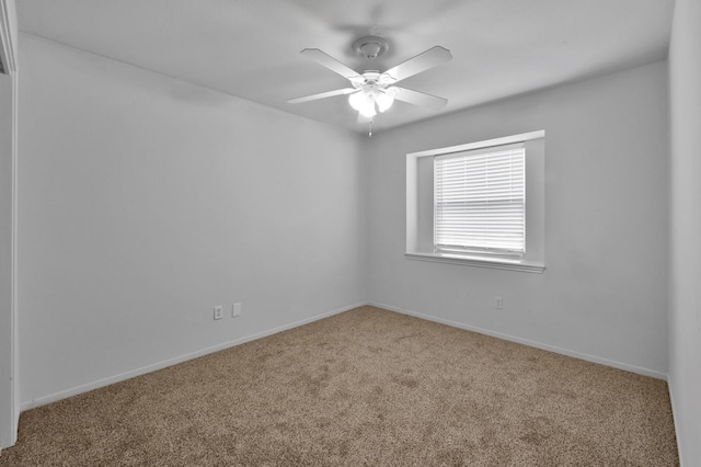spare room featuring a ceiling fan, baseboards, and carpet