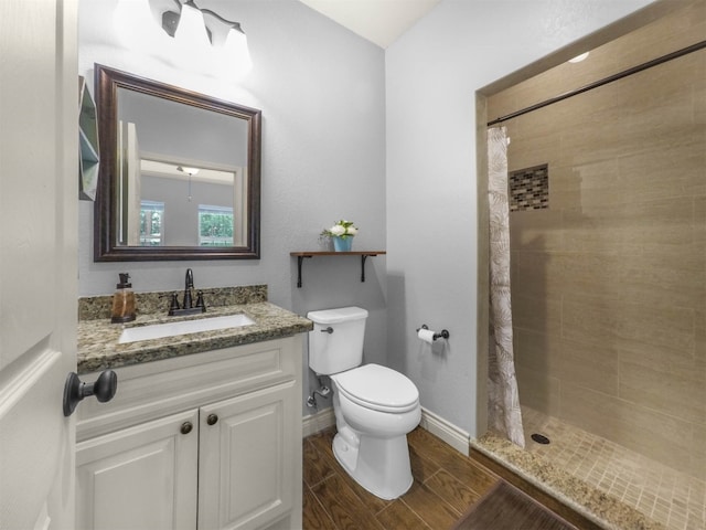19507 Balsas Dr, Porter, TX 77365 - bathroom with vanity, baseboards, toilet, tiled shower, and wood tiled floor
