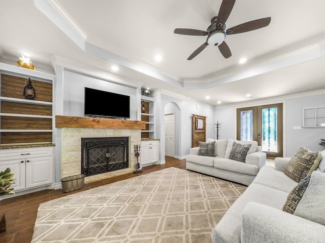 19507 Balsas Dr, Porter, TX 77365 - living room with a fireplace, a tray ceiling, ornamental molding, a ceiling fan, and wood finished floors