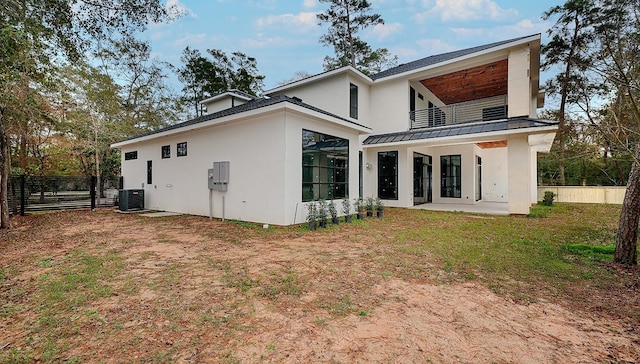 back of house featuring central AC unit, a patio area, fence, stucco siding, and a balcony