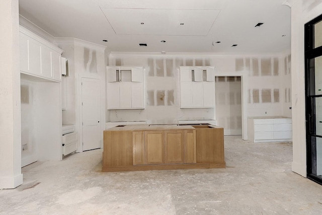 kitchen featuring white cabinets, crown molding, and a kitchen island