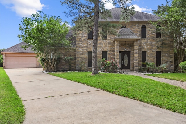 view of front facade featuring concrete driveway, roof with shingles, a front yard, brick siding, and a garage