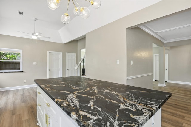 kitchen with white cabinets, ceiling fan, dark stone counters, and wood finished floors