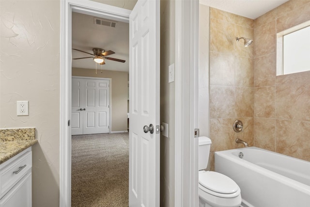 bathroom featuring visible vents, toilet, ceiling fan, vanity, and shower / tub combination